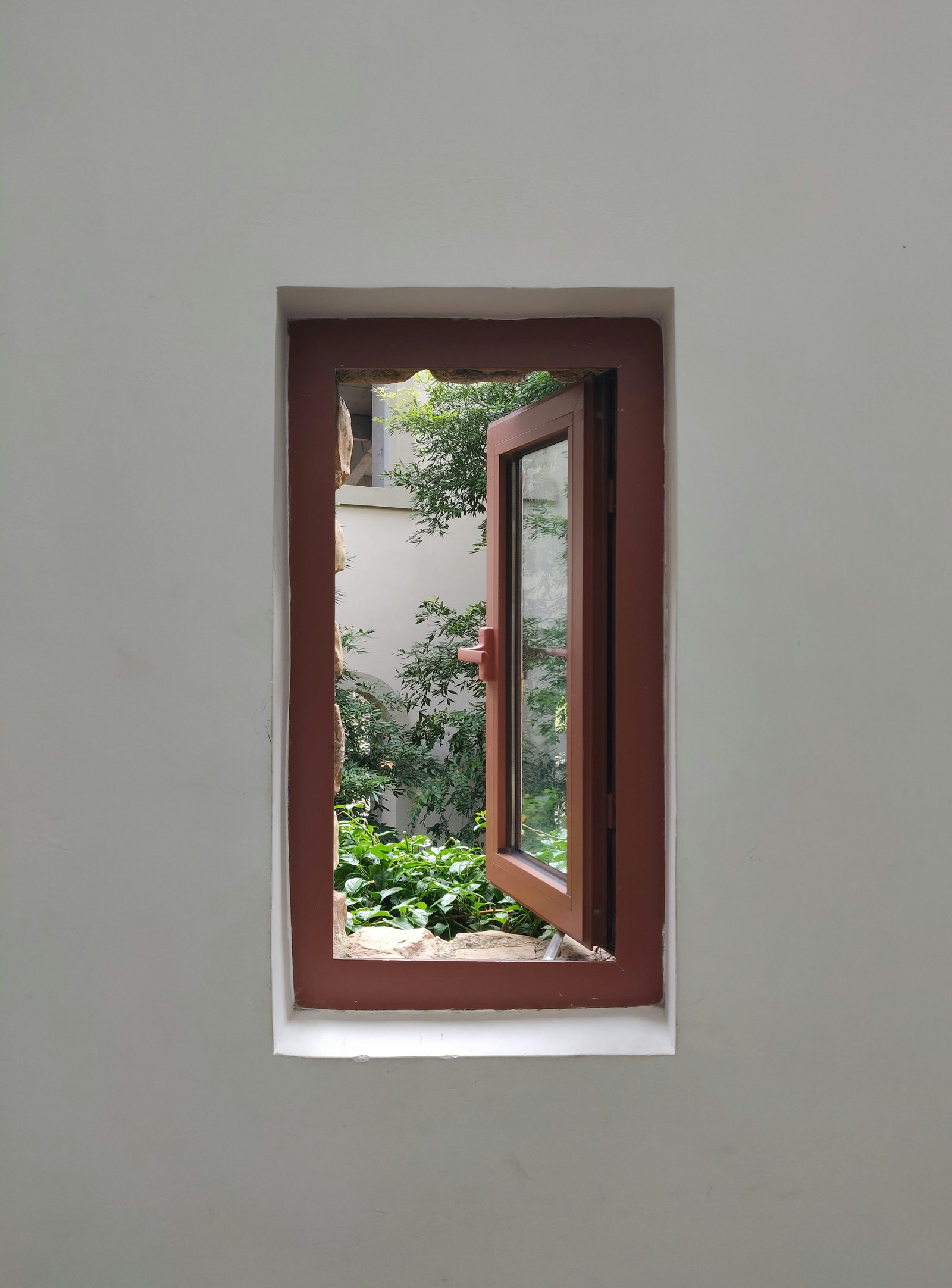 Wood door opened onto a planted courtyard