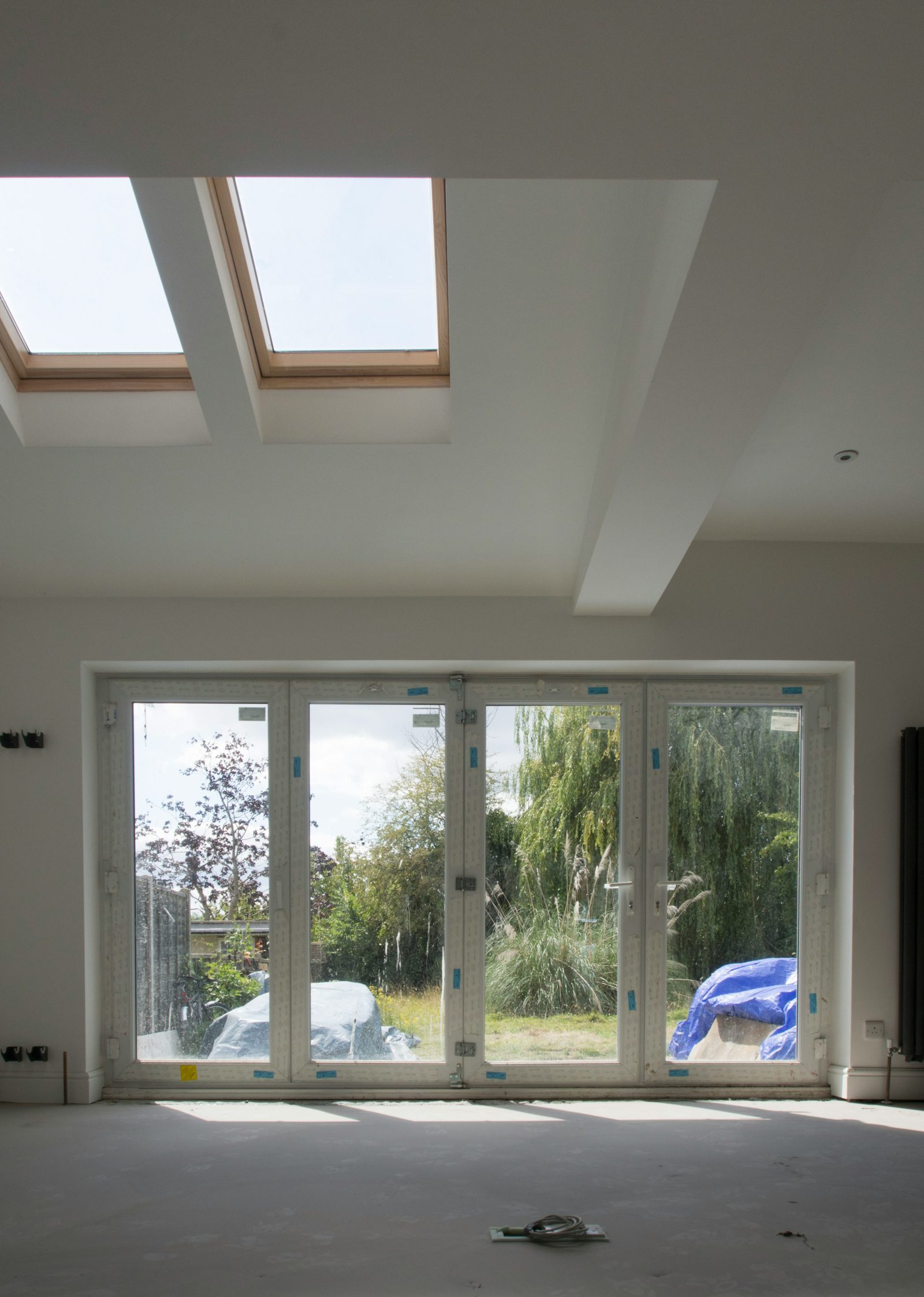 Bright room lit by roof lights above French doors