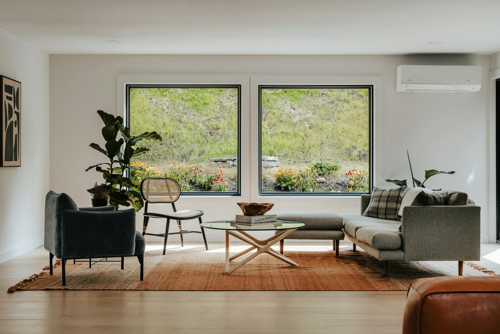 Living room with wide picture windows looking onto greenery