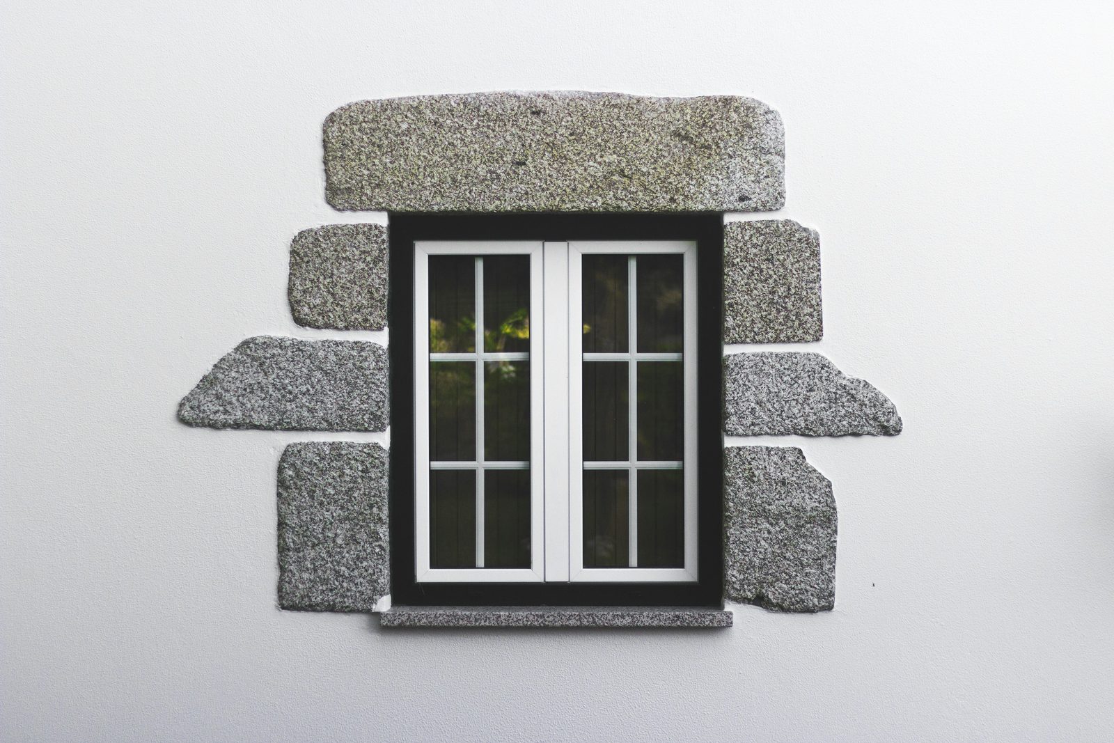 White tilt-and-turn window set in a stone surround